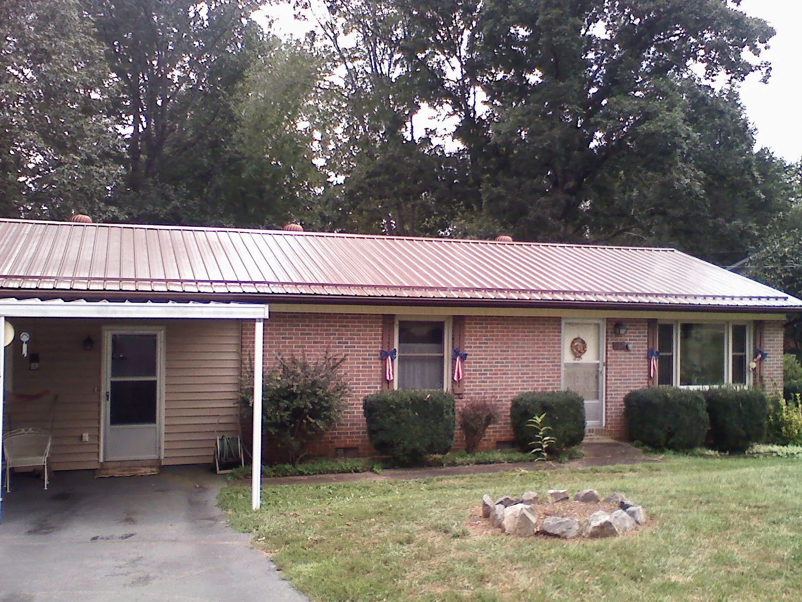 Bronze metal roof and carport on a brick ranch home — Roof Repair work by our crew in Armona