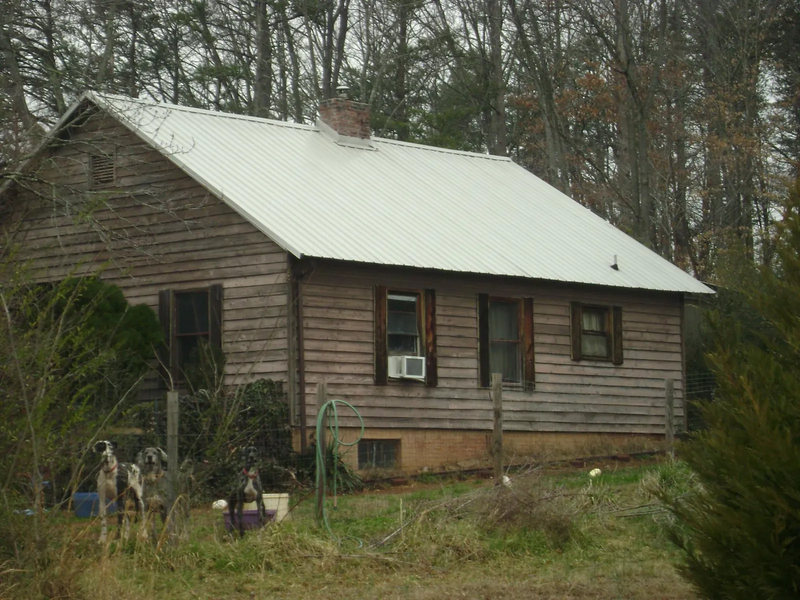 White metal roof on an old wood sided farmhouse, from a Metal Roof Installation job in Armona